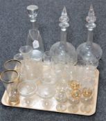 A tray containing antique etched drinking glasses, three glass decanters with stoppers,