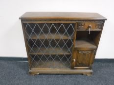 A Priory oak sliding glass door bookcase fitted with a cupboard and drawer