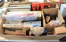A box containing vintage annuals, film reels, modelling kits,