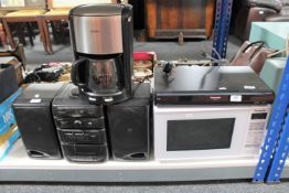 A Panasonic DVD player with remote together with a Panasonic microwave, Krups coffee maker,
