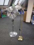 A brass angle poise floor lamp together with an oscillating floor fan
