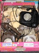 A box containing six retro plastic telephones