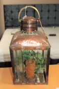 An antique copper and brass hurricane lamp