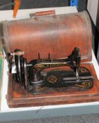 A vintage Singer hand sewing machine in case