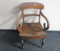 An antique pine scroll arm armchair
