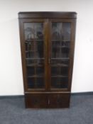 An early 20th century oak double door glazed bookcase