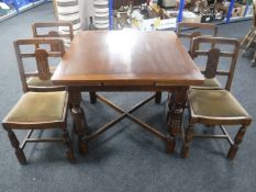 An early 20th century oak pull out dining table together with four chairs