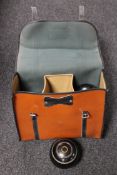 A leather lawn bowls bag containing a set of four bowls