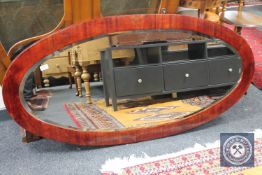 A large oval framed bevelled mirror