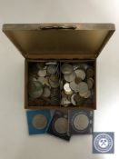 A cigarette box of assorted foreign coins,