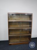 A mid 20th century four tier stacking glazed door bookcase