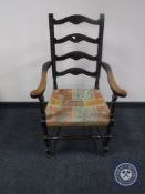An early twentieth century oak ladder backed armchair