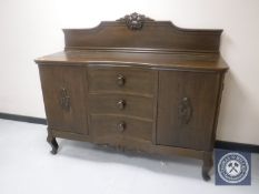 An early 20th century oak serpentine fronted sideboard
