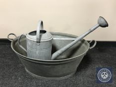 A galvanised twin handled wash tub with watering can