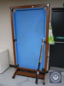 A folding snooker table with dart board and accessories