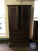 A hardwood double door cabinet fitted with eight drawers beneath