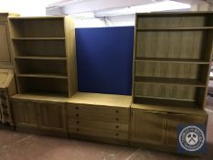 A blonde oak twin section bookcase fitted with cupboards beneath together with a similar four