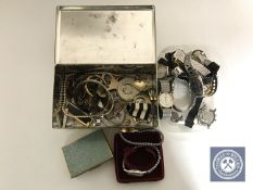 A tin of assorted costume jewellery,