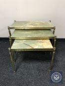 A nest of three brass and onyx tables