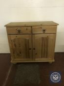 A pine double door sideboard fitted with two drawers