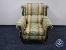 A wooden framed armchair upholstered in Regency style fabric