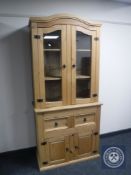 A pine glazed door bookcase fitted with double cupboard and drawers beneath