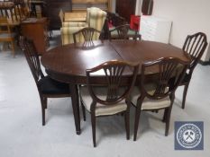 An oval mahogany dining table and six shield back chairs