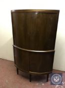 A mid twentieth century walnut double door bowfront corner cabinet
