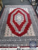 An Eastern design carpet on red ground,