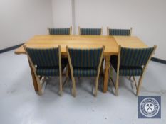A blonde oak refectory dining table with extension leaves together with six chairs upholstered in