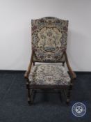 A continental oak scroll arm armchair upholstered in a tapestry fabric