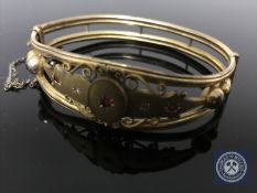 A Victorian gilt metal and synthetic ruby bangle