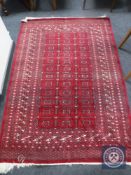 A fringed Afghan Tekke rug on red ground,