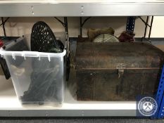 A flat packed cast metal patio table and two chairs with a vintage tin trunk and a fishing rod.