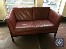 A late twentieth century Danish wooden framed red leather two seater settee