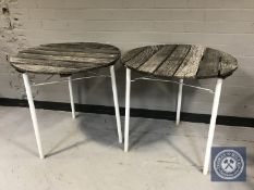 A pair of wooden cafe tables on metal legs