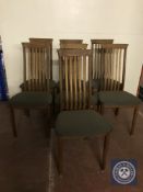 A set of seven teak rail backed dining chairs