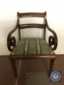 An antique mahogany scroll arm armchair