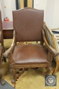 A carved oak 17th century style armchair in brown studded leather