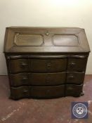 A late nineteenth century serpentine fronted bureau on claw and ball feet fitted with three drawers