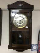 A 20th century oak wall clock with silvered dial plus pendulum and weights