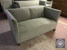 A late 20th century settee upholstered in green fabric