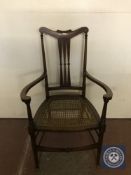 An antique inlaid mahogany bergere seated armchair