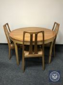 A Nathan teak display unit together with circular dining table and three chairs