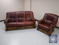 A wooden framed brown leather three seater settee and matching armchair
