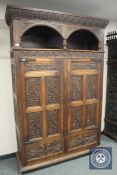 A 19th century carved oak double door cabinet fitted with two drawers, width 144 cm.