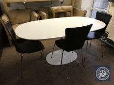 An oval contemporary white pedestal dining table together with a set of three black leather chairs