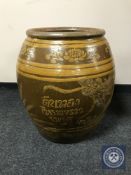 A large glazed earthenware barrel planter