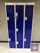 A triple section metal locker with seven compartments with keys