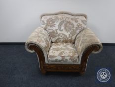 A wooden framed armchair in floral fabric